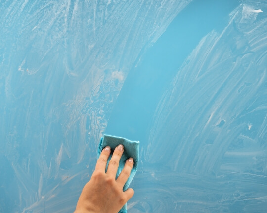 Hand cleaning a dirty window