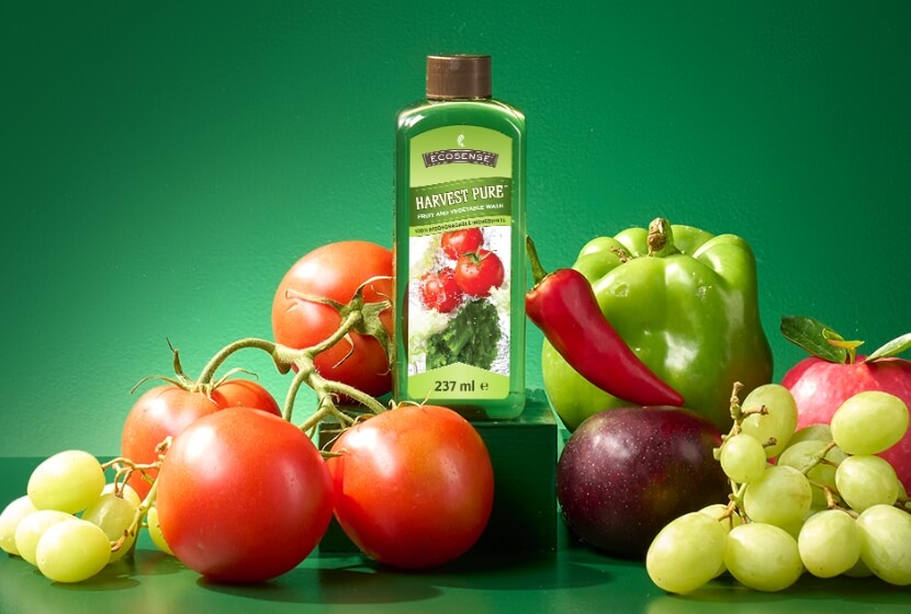 A bottle of Harvest Pure, surrounded by fruits and vegetables.