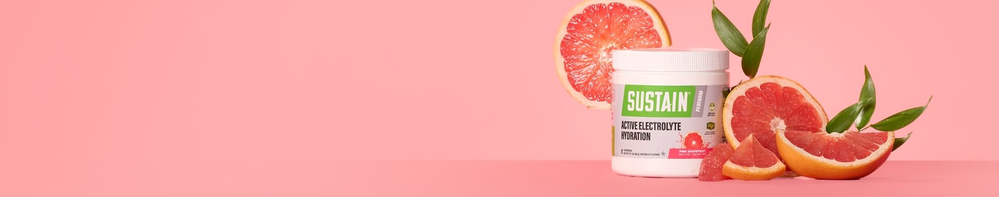 Sustain Active Electrolyte Hydration on a pink background, surrounded by fresh grapefruit slices.
