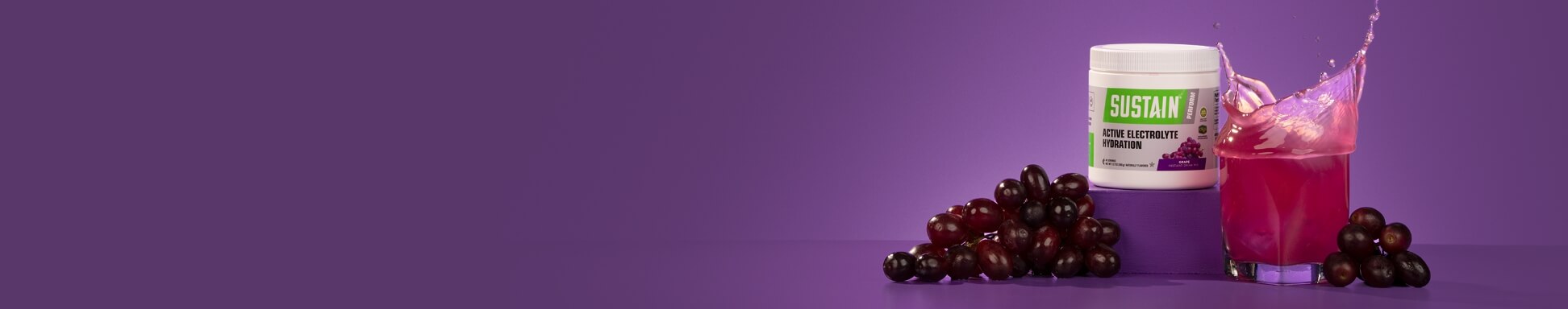 Grape sustain with grapes and a sloshing glass of purple liquid 