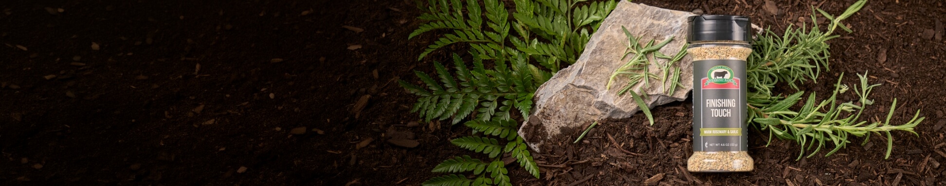 Finishing touch seasoning on a natural backdrop of herbs, stone, and soil