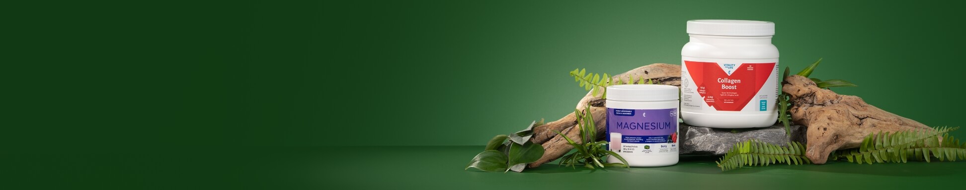 Collagen Boost and Melaleuca Magnesium surrounded with plants and driftwood against a green background