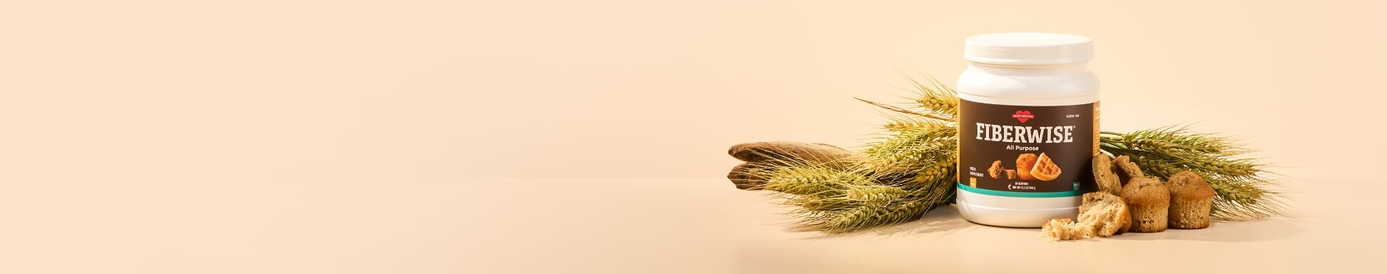 A canister of All-Purpose FiberWise surrounded by wheat stalks and freshly-baked goods.