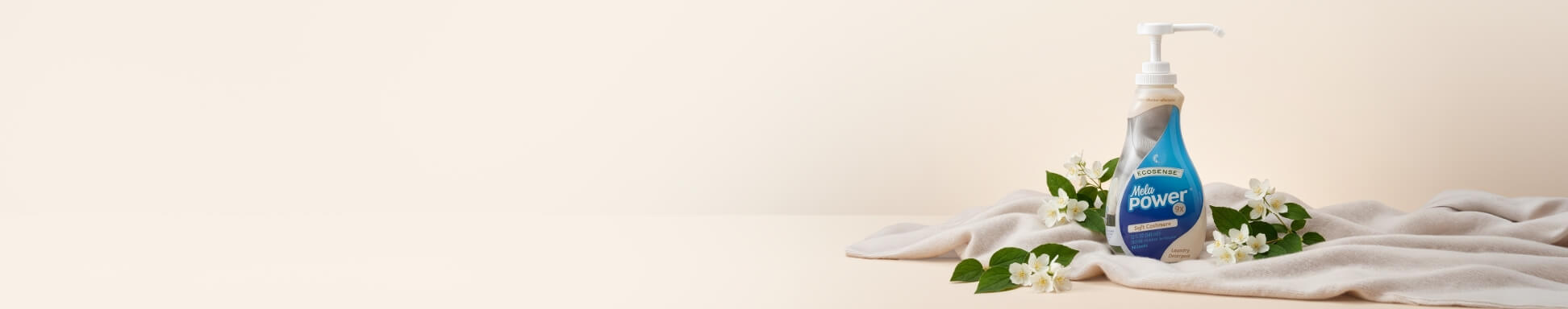 Melapower surrounded by white flowers posed on a white blanket on a cream backdrop