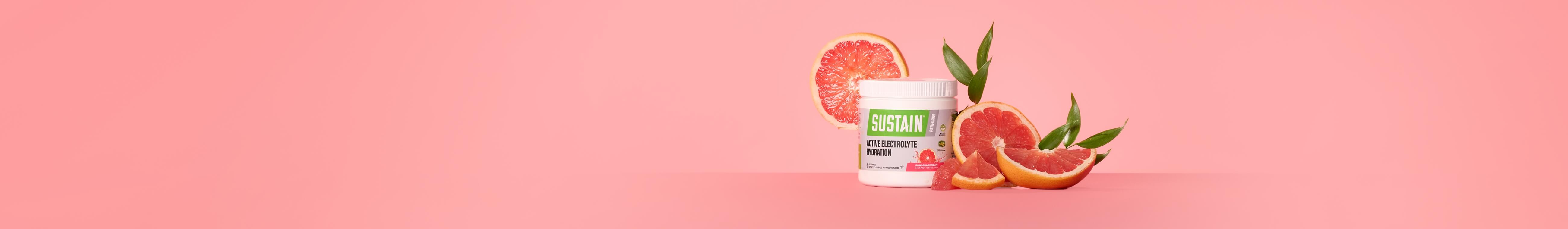 A canister of Sustain Active Electrolyte Hydration surrounded by slices of grapefruit and green leaves.