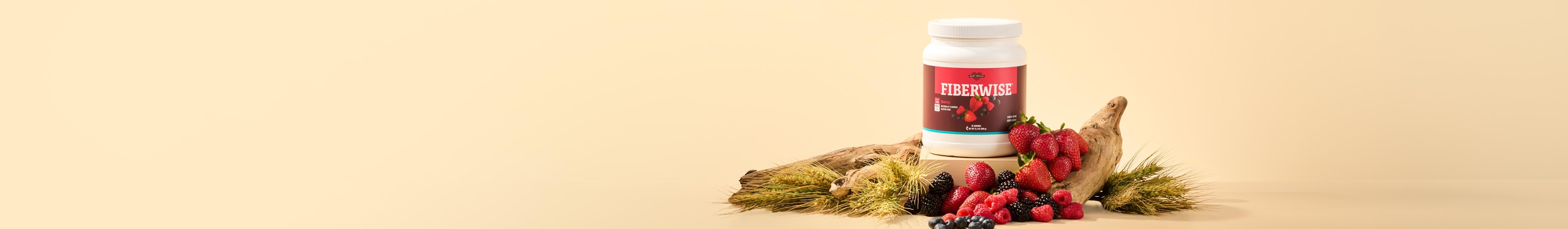 A canister or Berry FiberWise, surrounded by fresh berries and wheat stalks.
